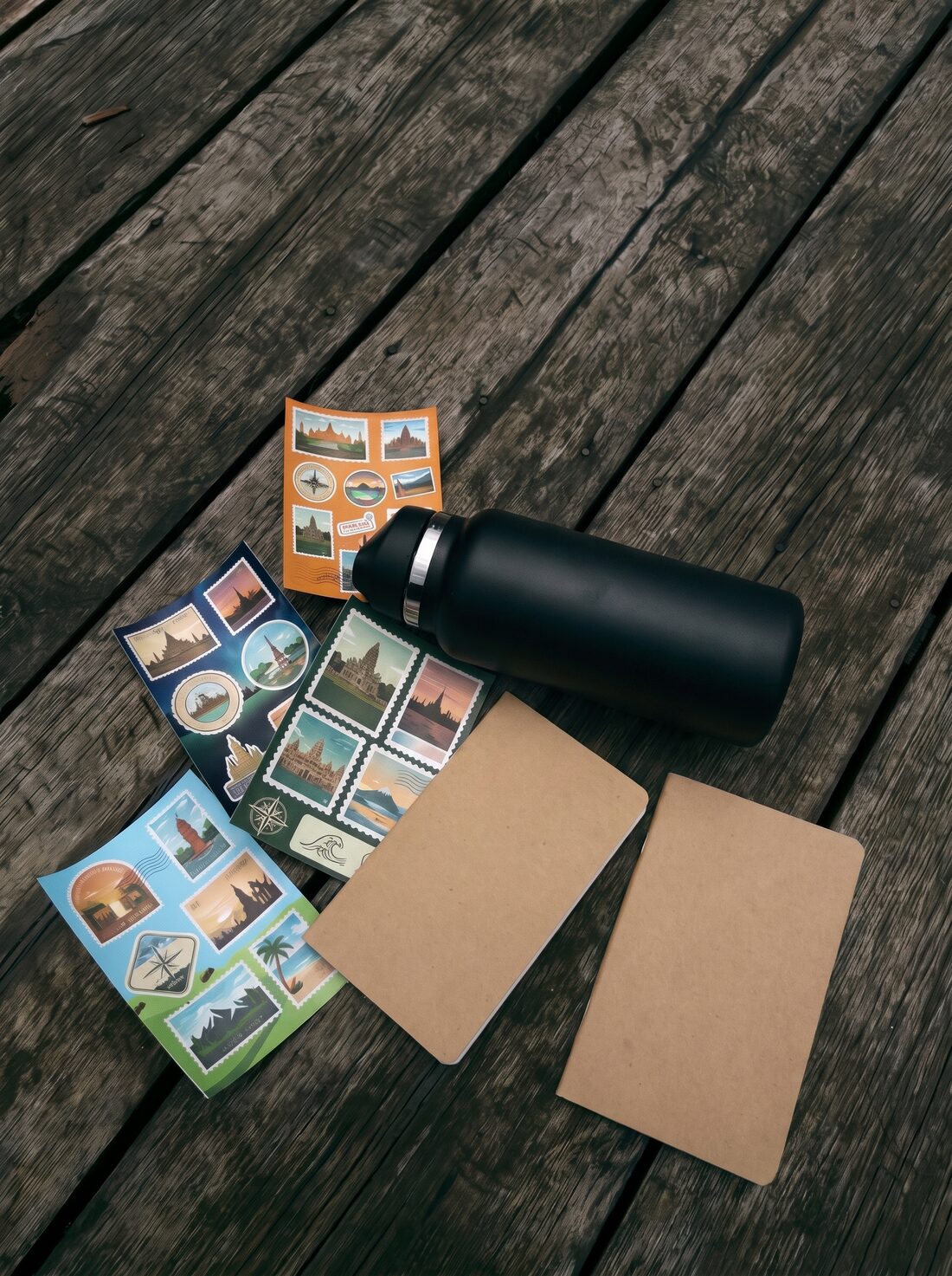 Custom die-cut travel stickers scattered on a wooden deck